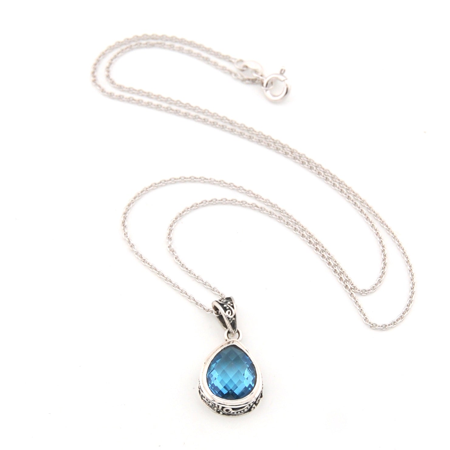 Silver necklace with a blue teardrop pendant on a white background