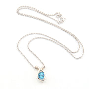 Silver necklace with a blue gemstone pendant on a white background