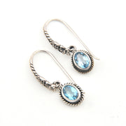 Silver earrings with blue gemstones on a white background