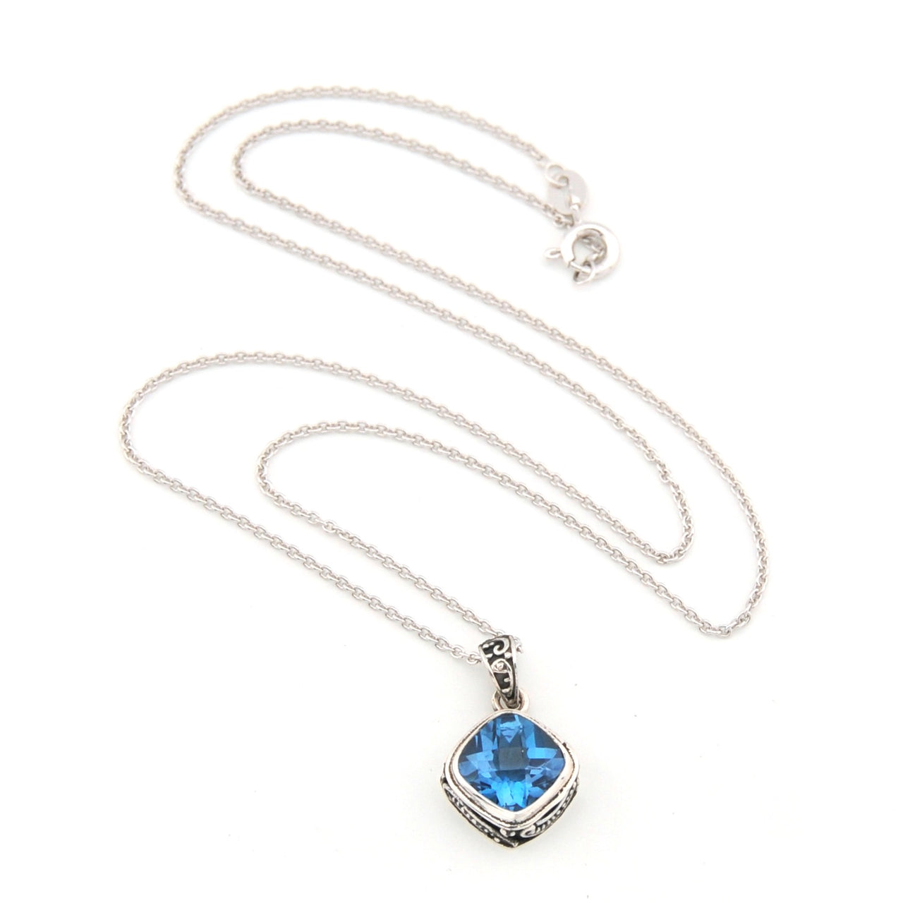 Silver necklace with a blue gemstone pendant on a white background