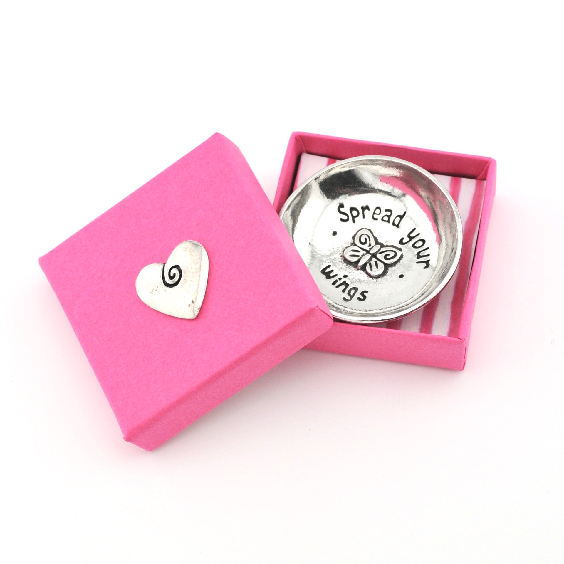 Silver trinket dish with 'Spread your wings' text and heart-shaped object in a pink box