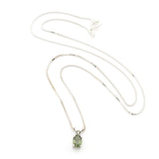 A silver chain necklace with a small oval green gemstone pendant, displayed on a clean white background.