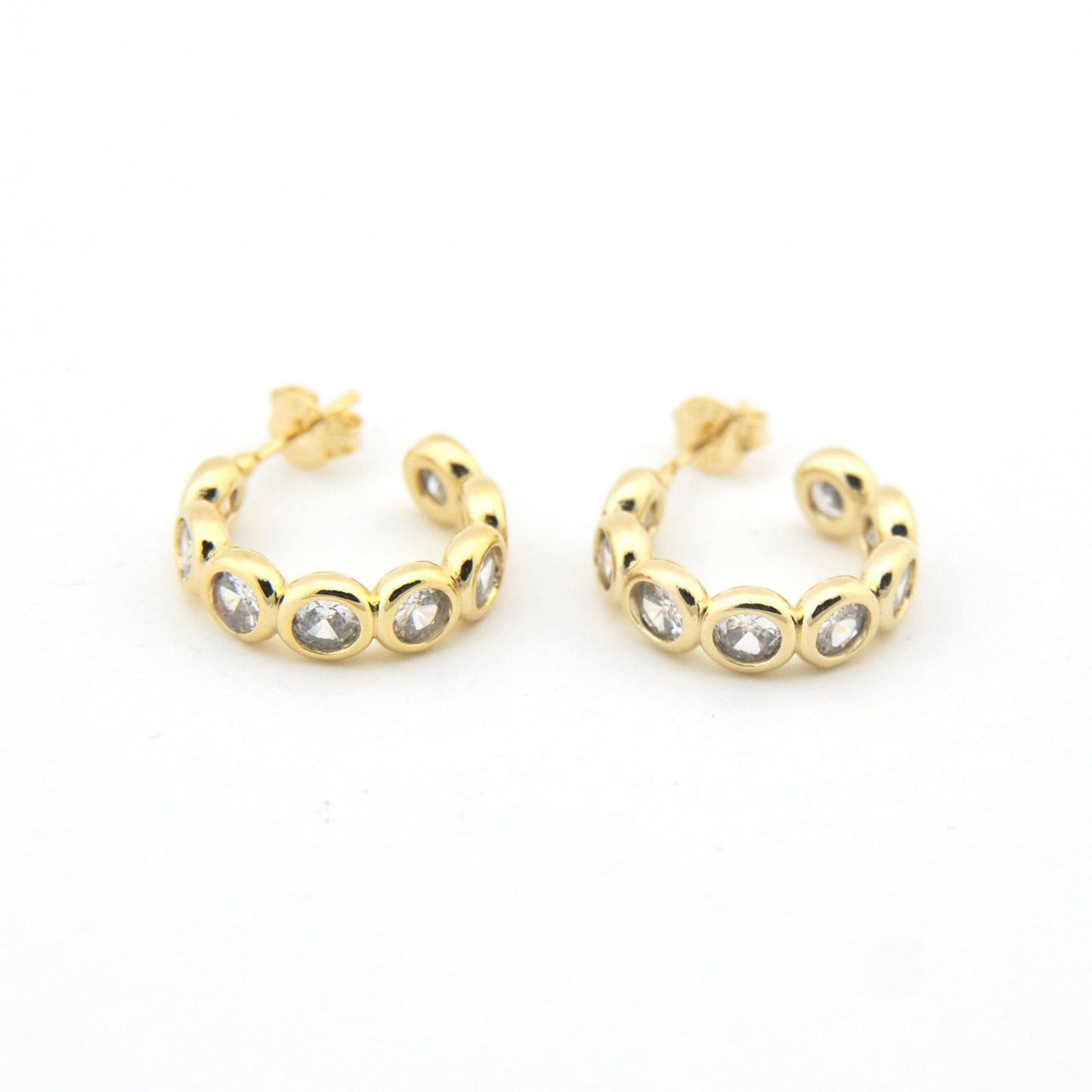 Gold hoop earrings with embedded stones on a white background