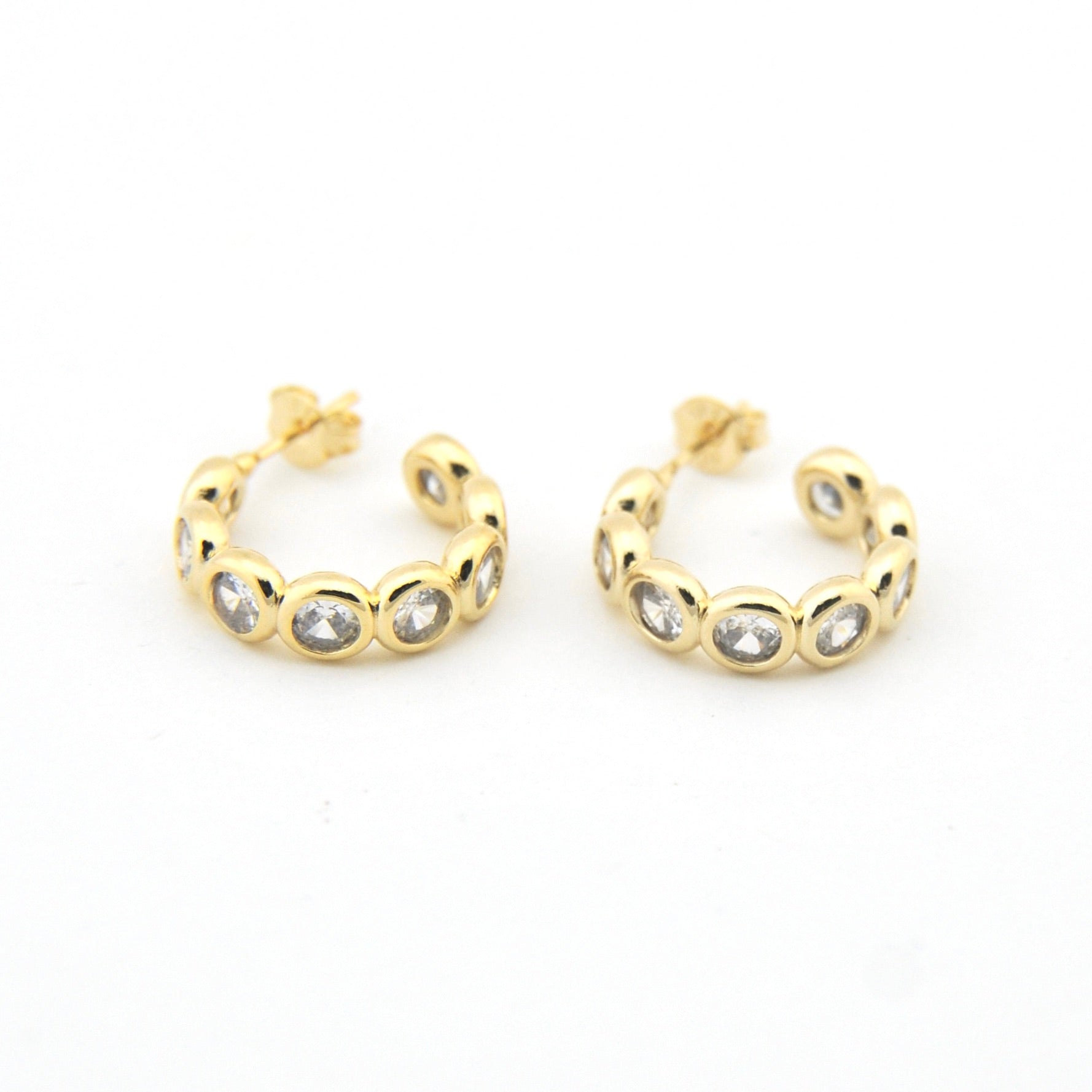 Gold hoop earrings with embedded stones on a white background