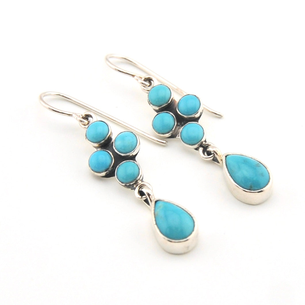 Turquoise and silver earrings on a white background