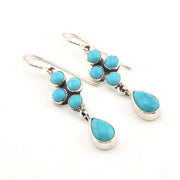 Turquoise and silver earrings on a white background