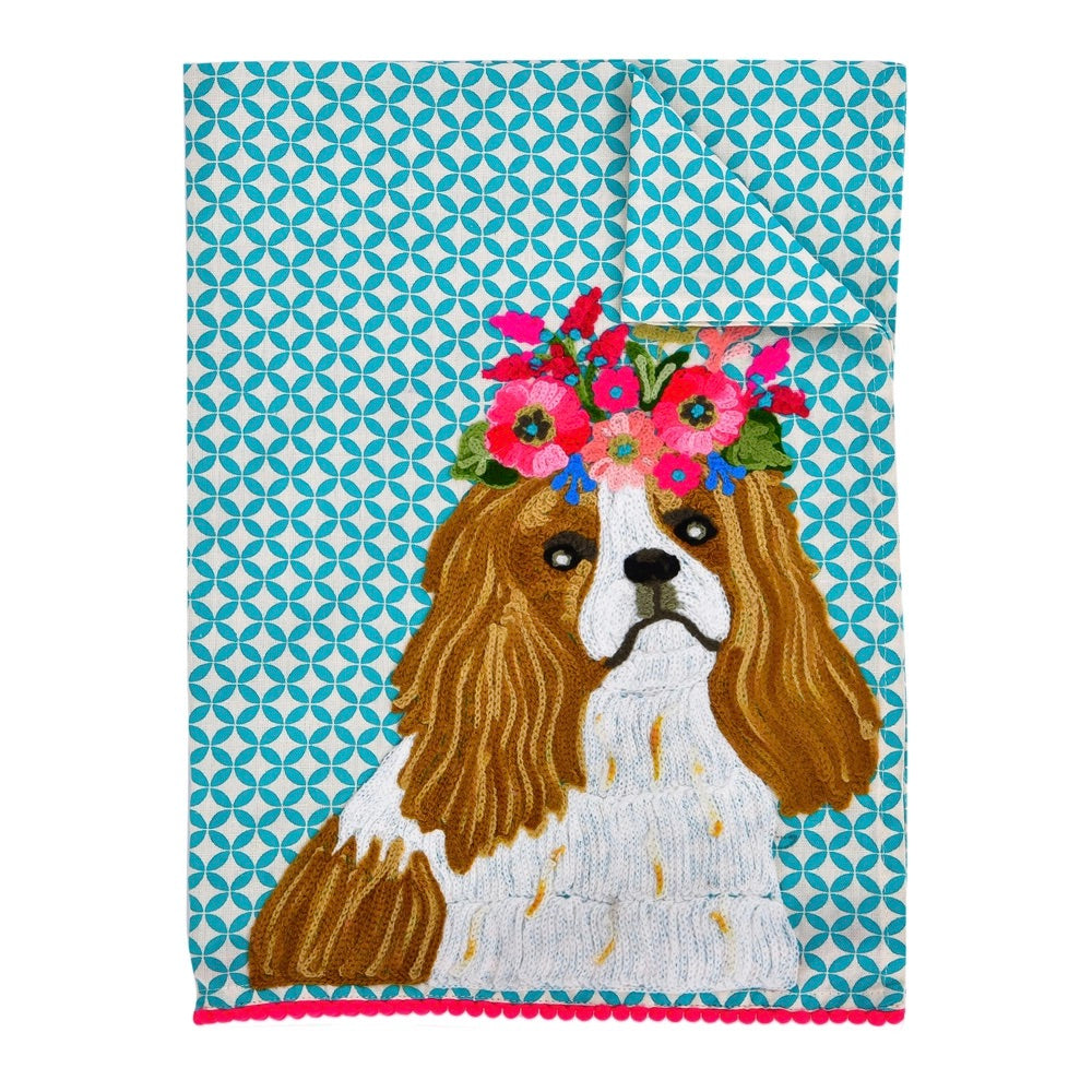 Embroidered towel with a dog wearing a floral crown on a blue geometric patterned background
