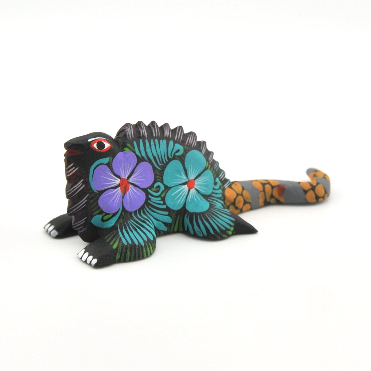 Colorful iguana figurine with floral patterns on a white background