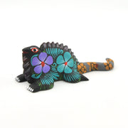 Colorful iguana figurine with floral patterns on a white background