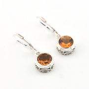 Silver earrings with round amber-colored gemstones on a white background