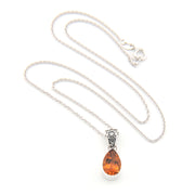 Silver necklace with a teardrop-shaped amber pendant on a white background
