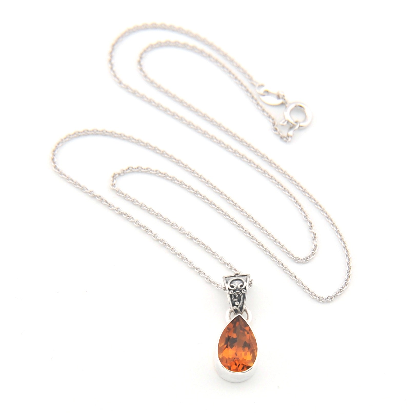 Silver necklace with a teardrop-shaped amber pendant on a white background