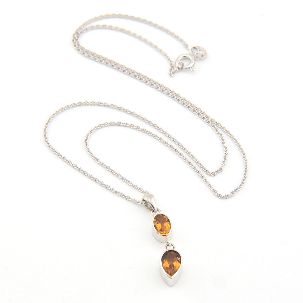 Silver necklace with two citrine teardrop pendants on a white background