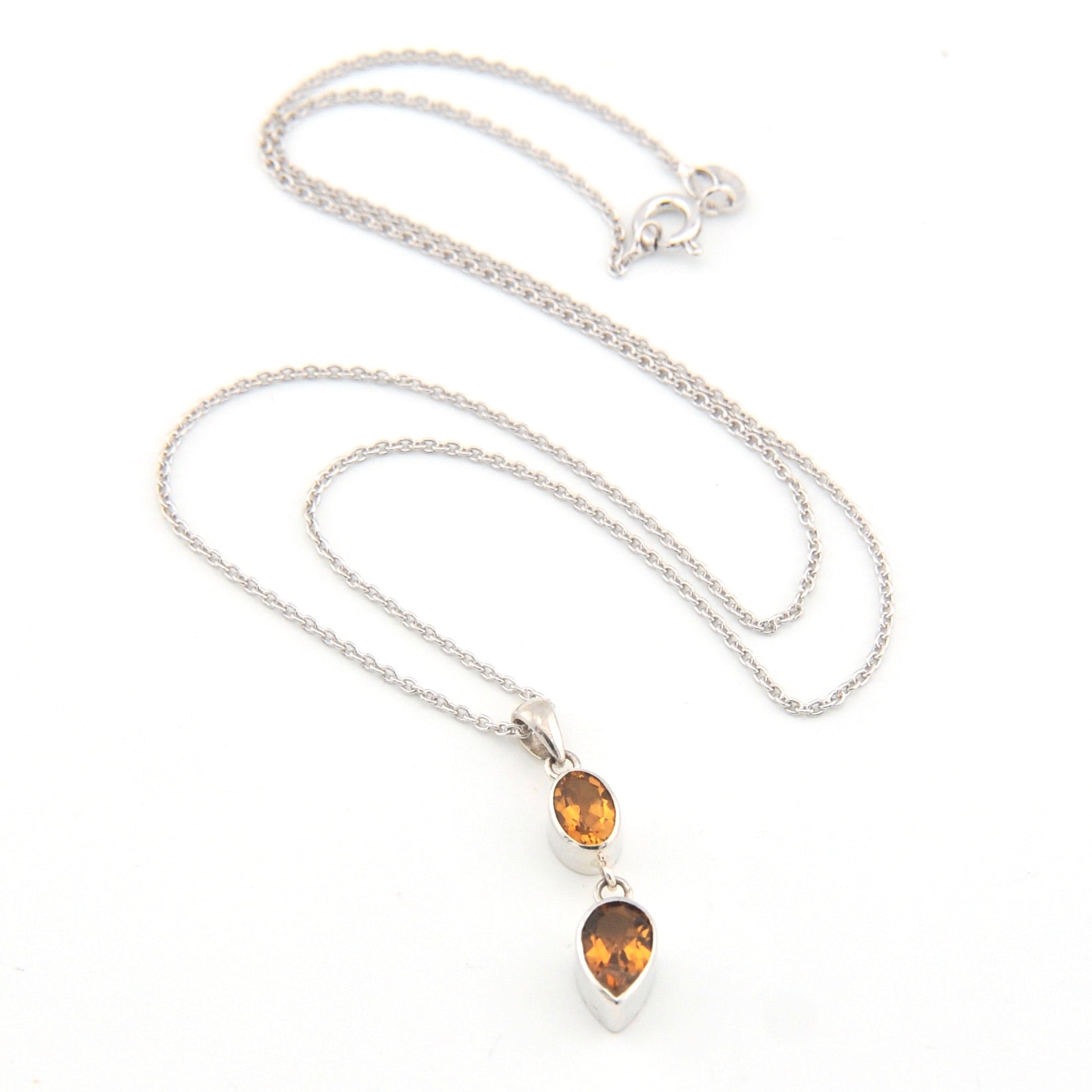 Silver necklace with two citrine teardrop pendants on a white background