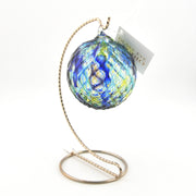 Decorative glass ornament with blue and yellow pattern on a white background