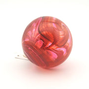 Red and pink marbled glass ornament on a white background