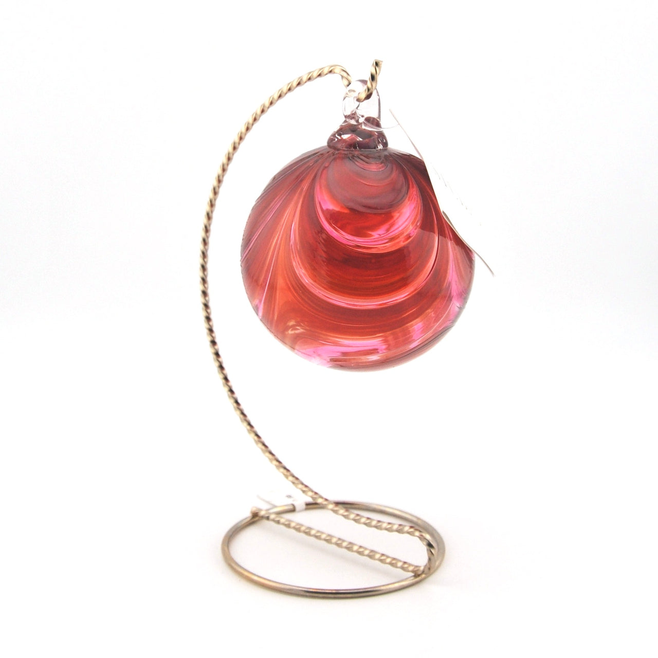 Pink glass ornament with a gold stand on a white background