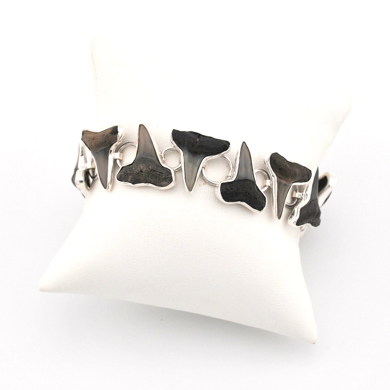 Silver bracelet with shark teeth on a white cushion