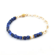 Bracelet with blue beads and gold accents on a white background