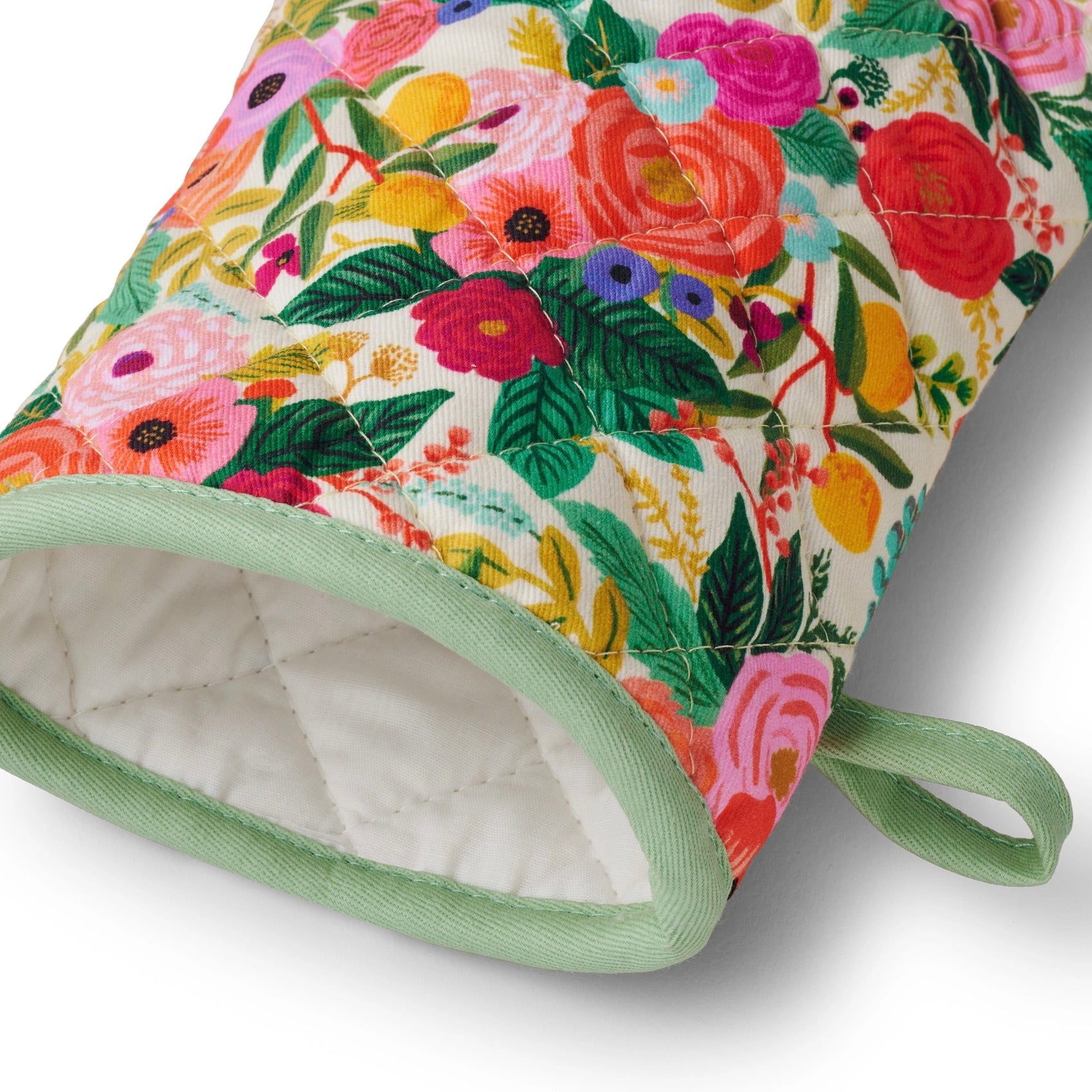 Floral patterned oven mitt with green trim on a white background