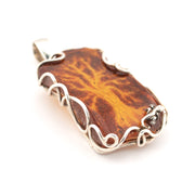 Brown stone pendant with silver wire wrapping on a white background
