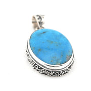 Turquoise pendant with silver setting on a white background