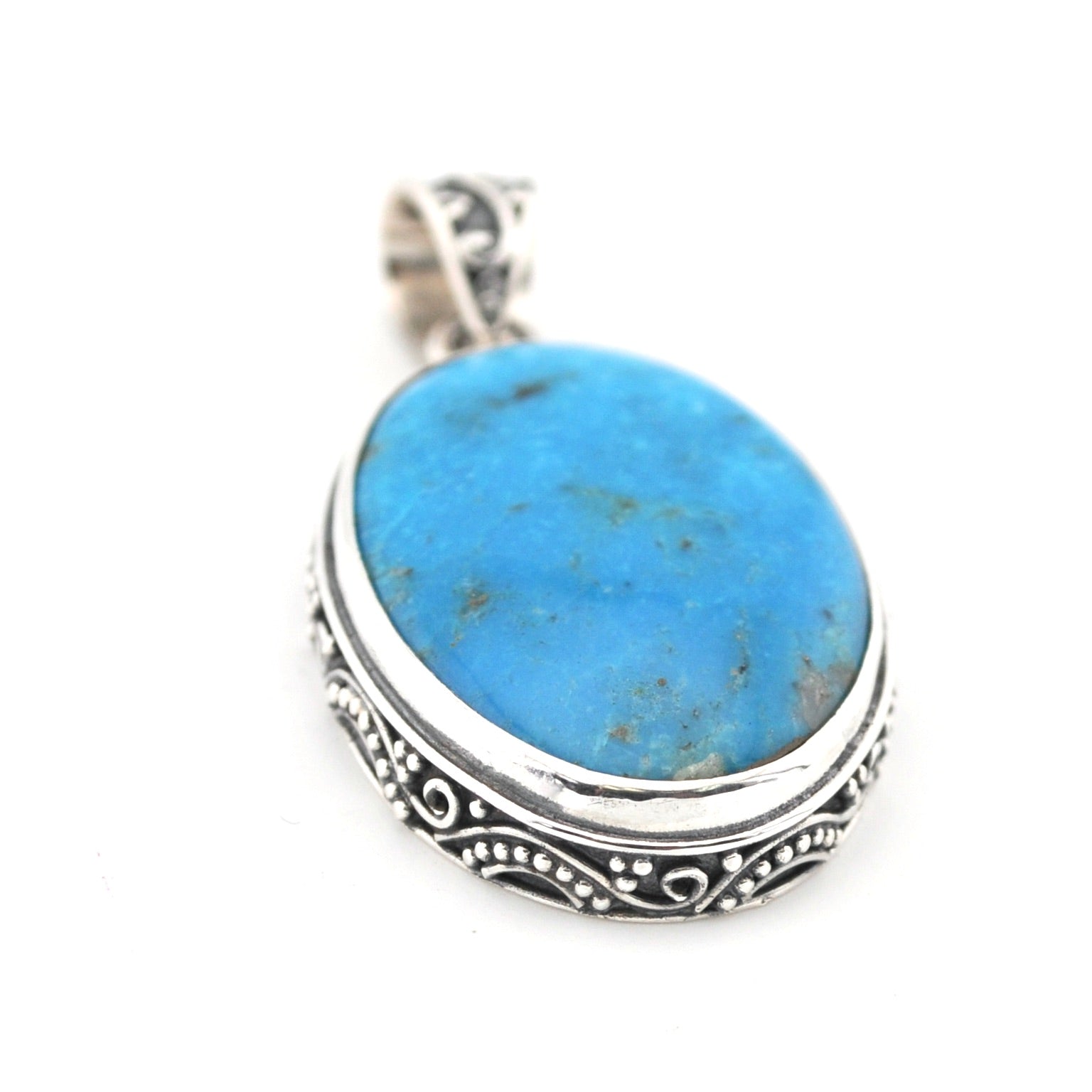Turquoise pendant with silver setting on a white background