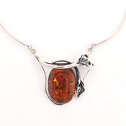 Silver necklace with a amber pendant on a white background