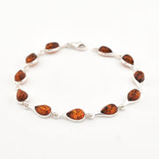 Silver bracelet with amber on a white background