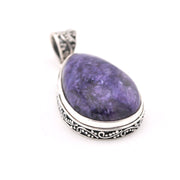 Purple teardrop pendant with silver setting on a white background