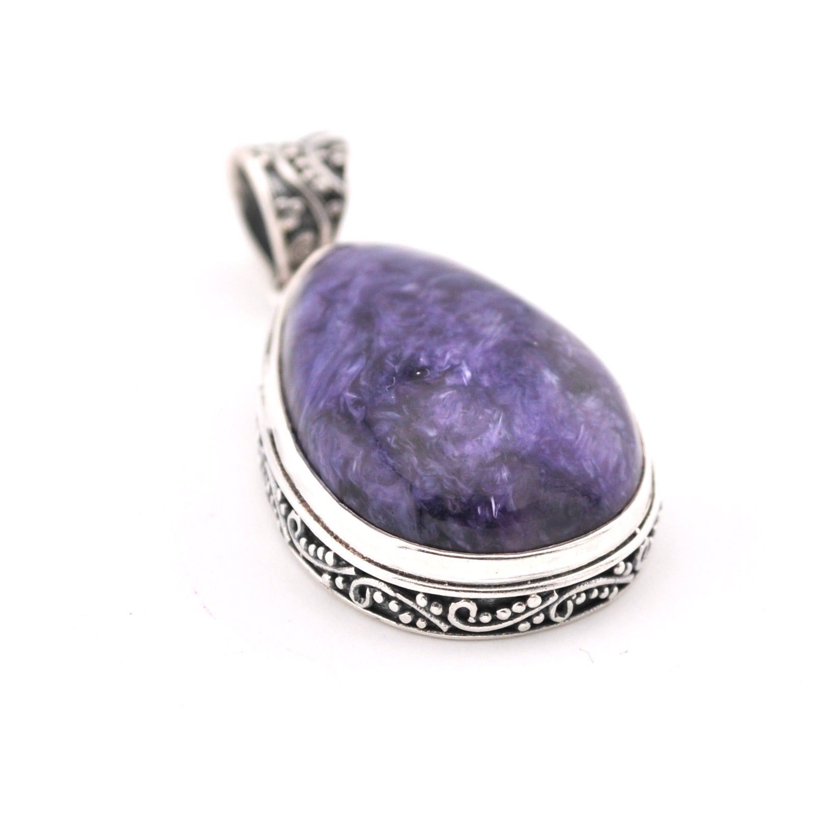 Purple teardrop pendant with silver setting on a white background