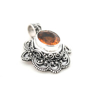 Silver pendant with a brown gemstone on a white background