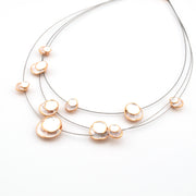 Necklace with gold and pearl-like pendants on a white background