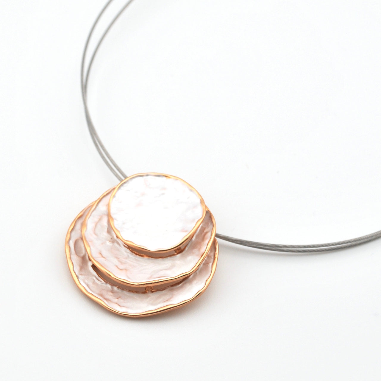 Necklace with a white and gold pendant on a white background