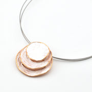 Necklace with a white and gold pendant on a white background