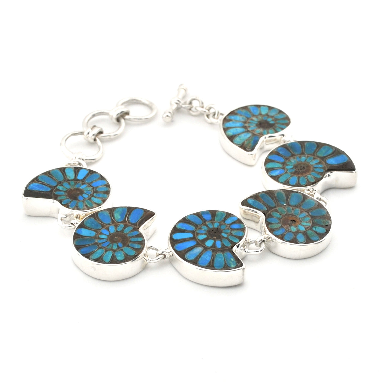 A silver link bracelet featuring six ammolite shell inlays with vibrant blue and green iridescent patterns, set against a plain white background.
