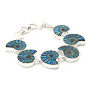 A silver link bracelet featuring six ammolite shell inlays with vibrant blue and green iridescent patterns, set against a plain white background.
