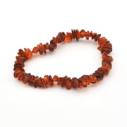 A handmade beaded necklace made of small, irregular, faceted amber chips in warm orange-brown tones, displayed on a clean white background.