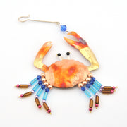 Decorative crab ornament with beads on a white background