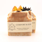 Two bars of soap with decorative elements on a white background, featuring the brand 'Comfort & Joy'.