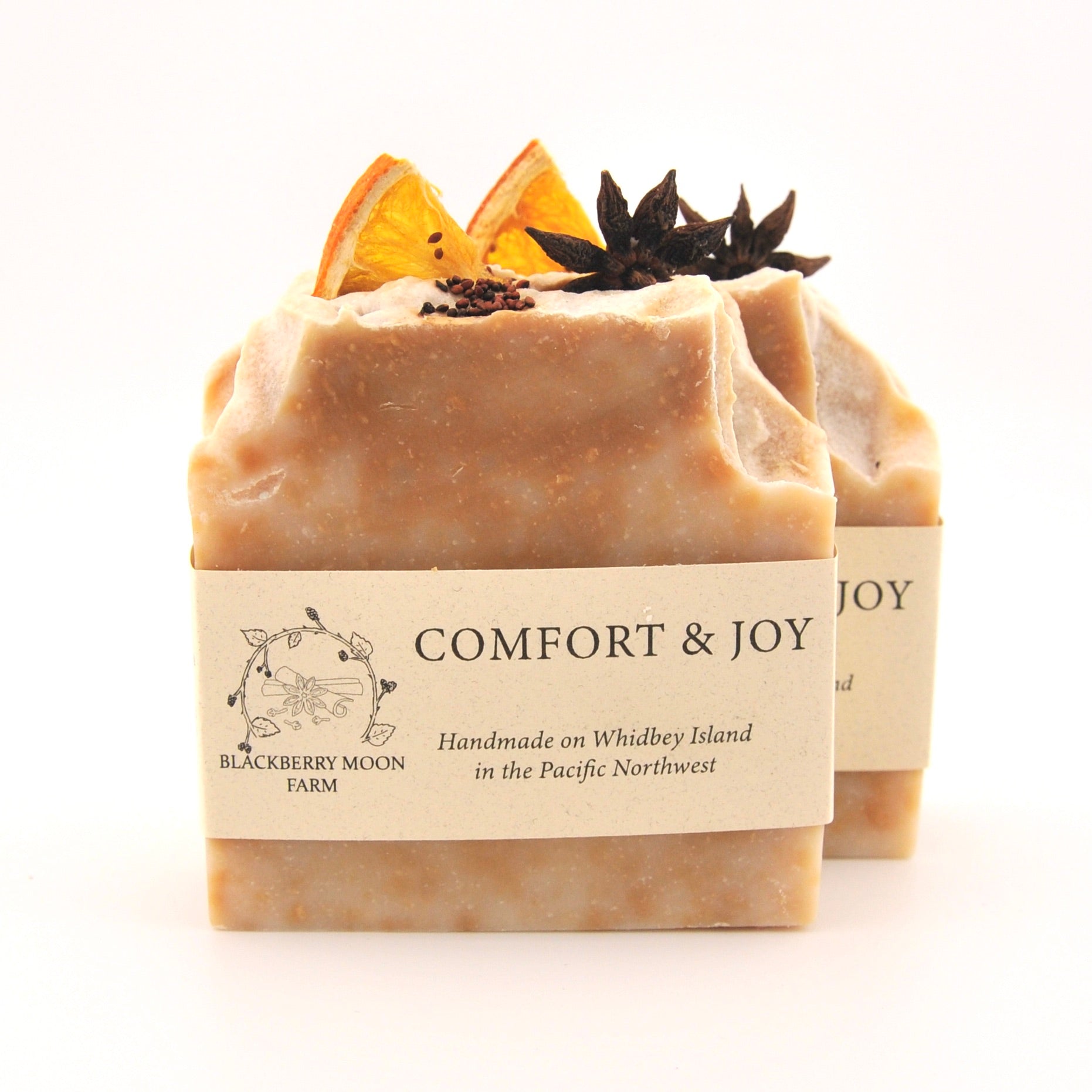 Two bars of soap with decorative elements on a white background, featuring the brand 'Comfort & Joy'.