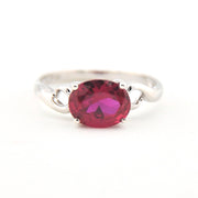 Silver ring with a red gemstone on a white background