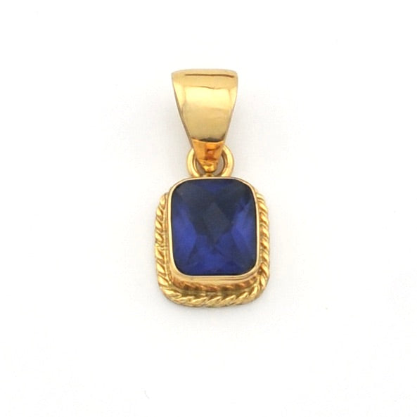 Gold pendant with a blue stone on a white background