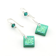 Green square earrings with intricate patterns on a white background