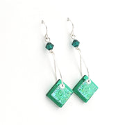 Green square earrings with beaded accents on a white background
