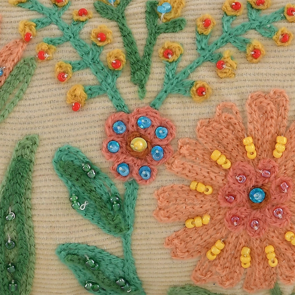 Close-up of embroidered flowers with beads on a textured fabric background