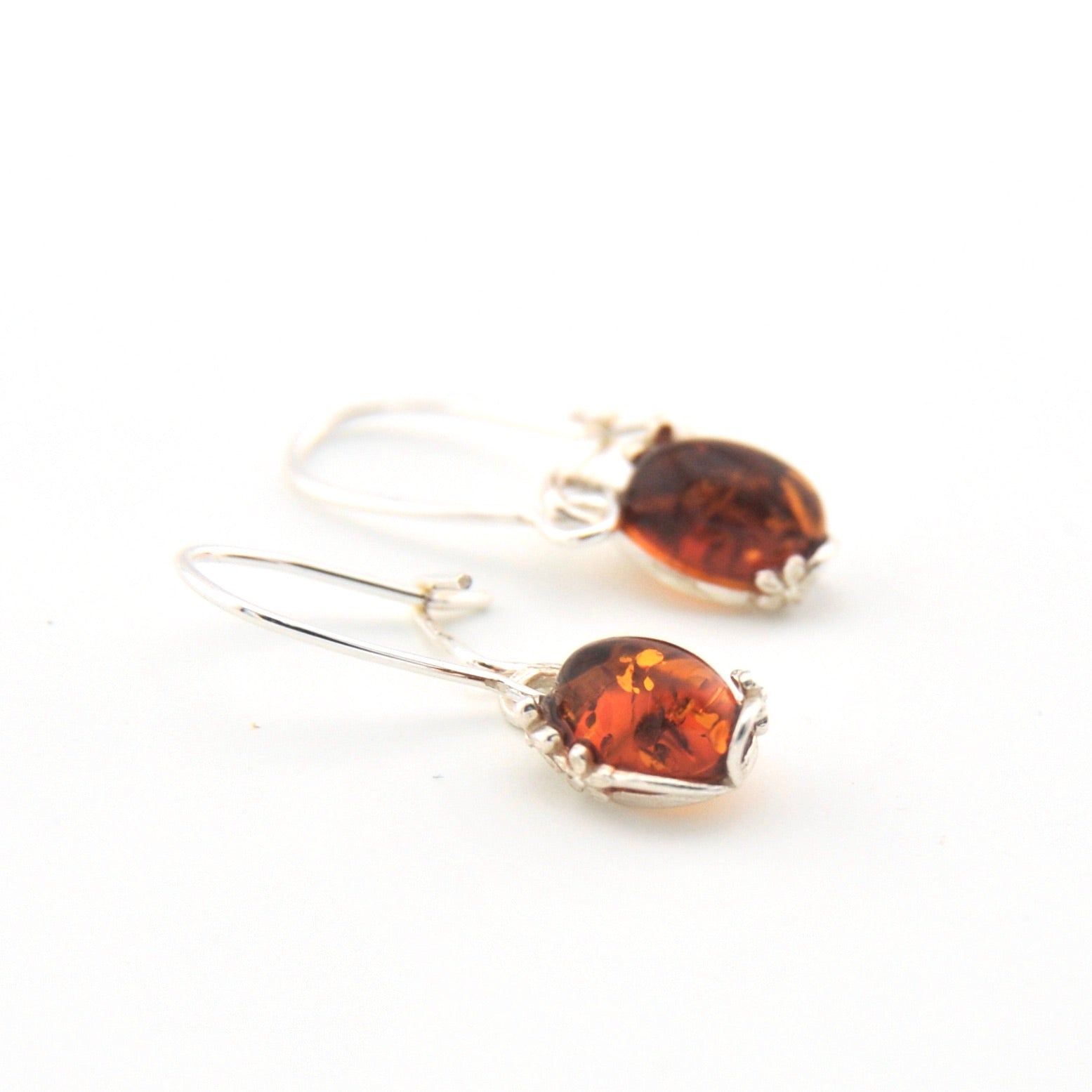 Pair of amber heart-shaped earrings on a white background