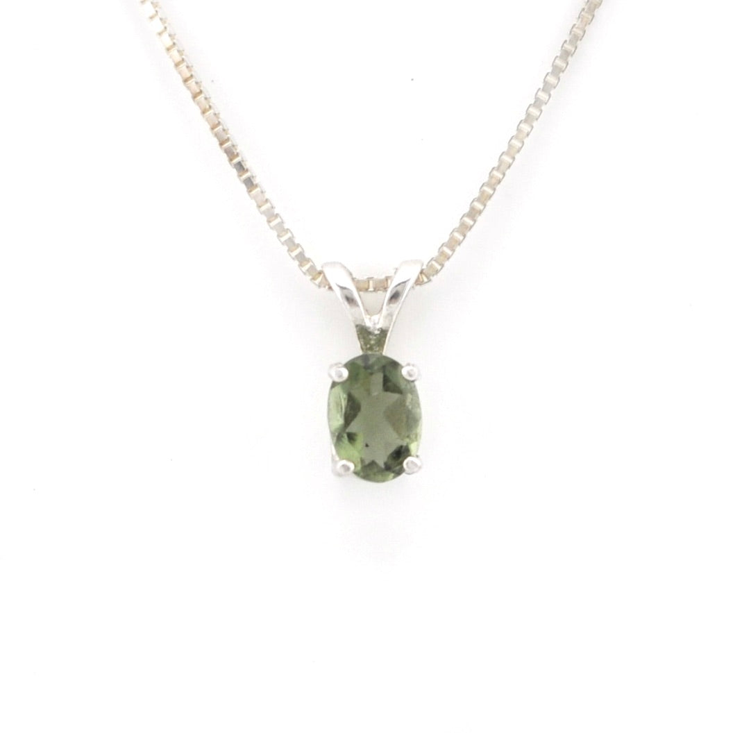 A silver pendant necklace featuring an oval-cut green gemstone in a four-prong setting, suspended from a delicate silver chain against a plain white background.