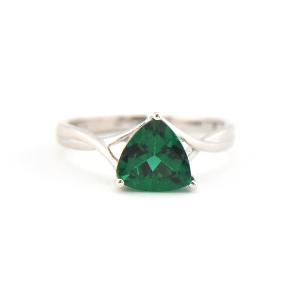 Silver ring with a green gemstone on a white background