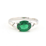 Silver ring with a green gemstone on a white background